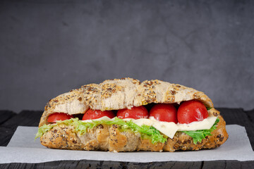 Ham sandwich on black wood