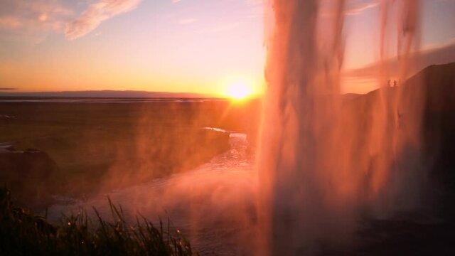 Slow motion 120fps: Seljalandsfoss spectacular waterfall in Iceland at Sunset Popular tourist destination Golden hour