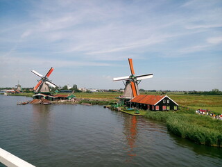 Fototapeta premium windmill, holland, mill, dutch, netherlands, water, landscape, wind, sky, old, architecture, blue, traditional, rural, river, kinderdijk, nature, green, village, europe, windmills, energy, farm, landm