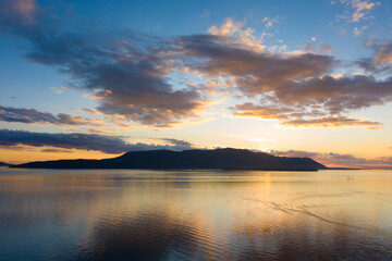 Sunset Over Orcas Island in the Salish Sea and the San Juan Island Archipelago. Beautiful and dramatic sunset with colorful clouds and a calm sea in the Pacific Northwest.