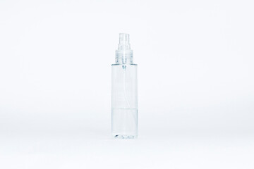 Transparent spray bottle for antiseptic or cosmetics with black button cap on light gray background.Coronavirus protection concept.