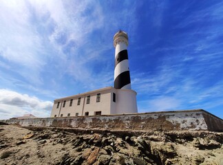 Black and white stripped tall lighthouse on Cape Favaritx on north coast of Menorca, Balearic...