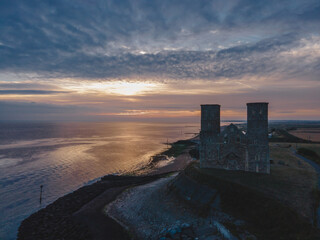 Drone aerial shot of Remains of Reculver church towers at early october sunrise  early october...