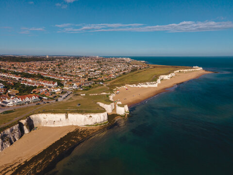 Drone aerial shot of View of sea at low tide and empty beach with Chalk Cliff Arch in Margate, England