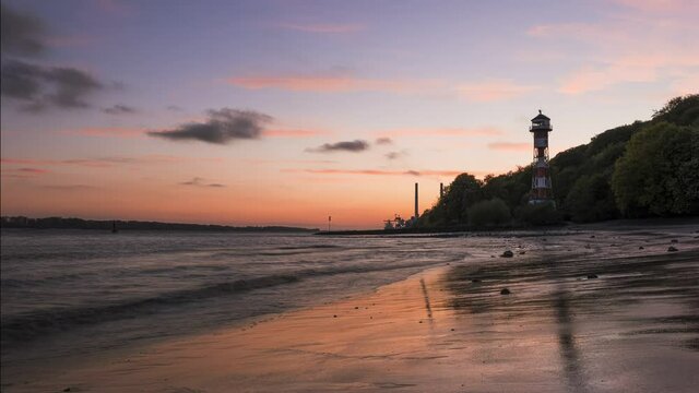  Timelapse of a beautiful sunset  with burning sky  at the river  Elbe near Hamburg with some cargo ships. 