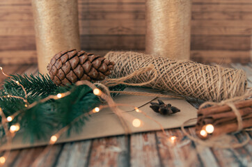 Christmas background with decorations. Christmas presents, pine twigs and cones on wood background. Cozy christmas composition.Winter time. Christmas holiday concept.
