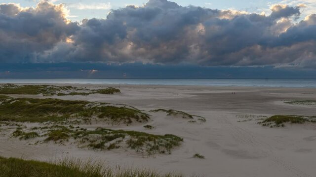 Amrum island, Germany: Time lapse of sun rays emerging through the dark storm clouds at the beach of Amrum. Sunset is obscured by a thick cloud front announcing bad weather