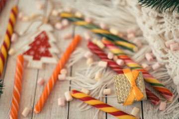 A lot of candies and white scarf on a white table before christmas eve. christmas present