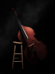 A double bass sits on a stool with a slightly smoky environment