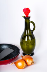 Bottle of vegetable oil, two whole onions, red frying pan and spatula for stirring on table. Selective focus. Kitchen tools. Kitchenware. Cookware. Prepare Food. Idea for design, banner, copy space. 