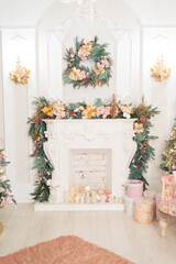 Fototapeta na wymiar beautifully decorated bright room for the holiday season. Christmas tree in pink colors, gifts are under the Christmas tree. the fireplace is decorated with garlands 