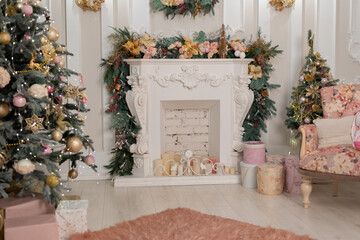 beautifully decorated bright room for the holiday season. Christmas tree in pink colors, gifts are under the Christmas tree. the fireplace is decorated with garlands
