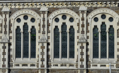 Three Decorative Arched Plaster Window Frames with Circles and Triangles on a Brick Building