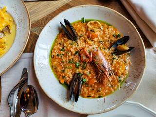 Risotto with seafood, langoustines and mussels are on the plate.