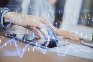 Double exposure of forex graph drawing and man and woman working together holding and using a mobile device. Trade concept.