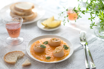 Fototapeta na wymiar Pan Seared Sea Scallops with Orange Tomato Sauce. Glass of Rose Wine
