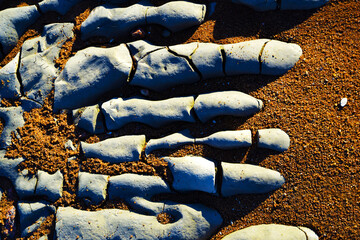 Hardened lava flow in the shape of a human hand. Volcanology. Red sand background. Basaltic magma...