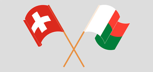 Crossed and waving flags of Madagascar and Switzerland