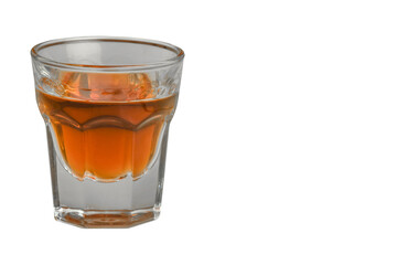 On a white background on the left side there is a glass of cognac. Close-up photographed.