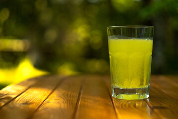 A glass of fizzy drink on a blurry background with bokeh