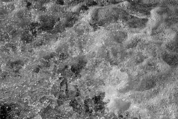 foaming,bubbling water. gray background, black and white photo