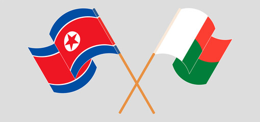 Crossed and waving flags of Madagascar and North Korea