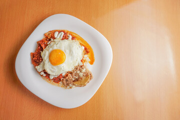 Huevos rancheros beans, tortilla chips, fried eggs, scrambled eggs with chili, comida corrida, mexican food, swooping view, overhead view



