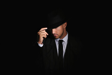 Old fashioned detective in hat on dark background - obrazy, fototapety, plakaty