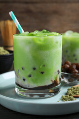 Tasty milk bubble tea with green matcha on blue plate, closeup