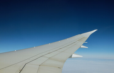 Fototapeta na wymiar Wing of an airplane flying above the clouds of an aircraft