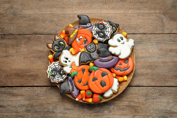 Tasty cookies and sweets for Halloween party on wooden table, top view