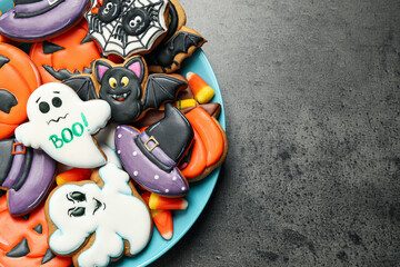 Tasty cookies and sweets for Halloween party on black table, top view. Space for text