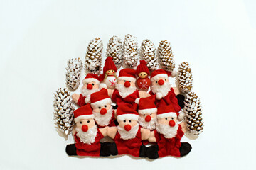 christmas toys of funny santa claus and snowmen with fir cones on a blurred white background
