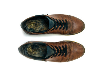 Old dirty brown leather shoes on an isolated white background. Concept, second hand, hard work,...