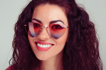 Woman in pink heart shaped sunglasses smiling