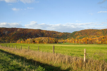Fototapeta na wymiar Beautiful Autumn Scene with Farm Fence and Mountains in the Background
