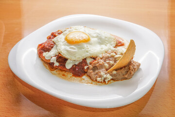 Huevos rancheros beans, tortilla chips, fried eggs, scrambled eggs with chili, comida corrida, mexican food, swooping view, overhead view


