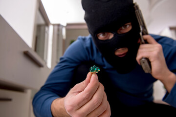 Male robber stealing valuable things from the house