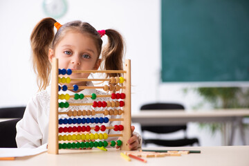 Small girl with abacus in the classroom