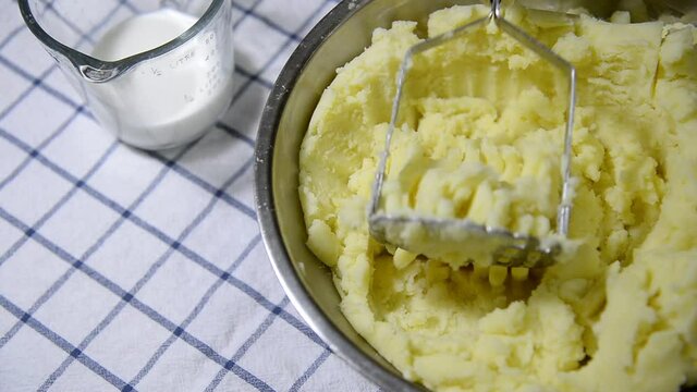 Chef making mashed potatoes close up at potato bowl - people with homemade cooking footage concept