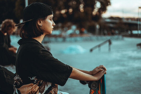 Chica joven urbana con mascarilla coronavirus pandemiua covid-19 en skatepark con patin skate longboard en verano en el sur de españa