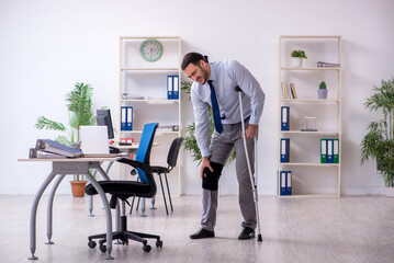 Young leg injured employee working in the office