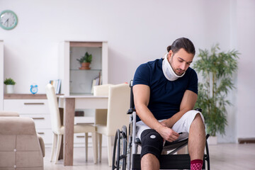 Young leg injured man in wheel-chair suffering at home