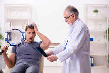 Obraz premium Young male tennis player visiting old doctor radiologist