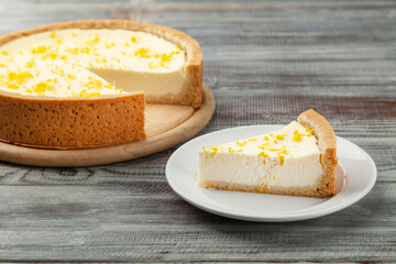Homemade lemon cheesecake and piece of pie near on plate