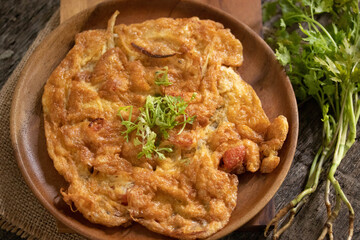Omelet in a plate on a wooden background