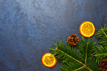 christmas food concept, fla tlay copy space text, dried oranges, fir branches and pine cones on dark concrete background