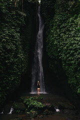 young woman backpacker looking at the waterfall in jungles. Ecotourism concept image travel girl