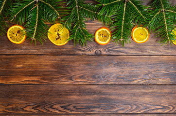 Christmas background with space for text, tree branches, dried oranges and cones on a wooden holiday table, flat lay, copy space text