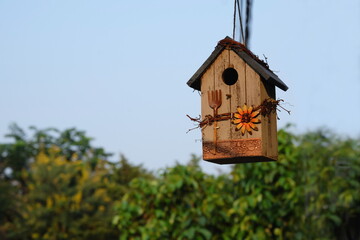 Obraz na płótnie Canvas A bird house decorated in a garden makes our backyard beautiful. And there are birds creating a fresh atmosphere in the backyard.